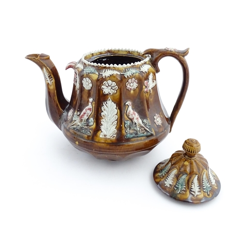 70 - A Victorian Measham bargeware teapot of fluted form decorated with flowers, ferns and birds. Approx.... 