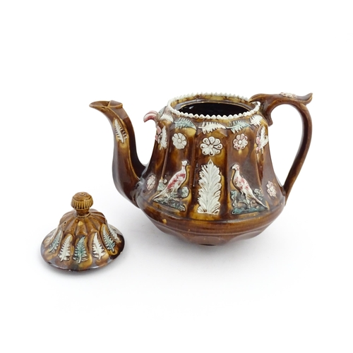 70 - A Victorian Measham bargeware teapot of fluted form decorated with flowers, ferns and birds. Approx.... 