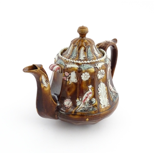 70 - A Victorian Measham bargeware teapot of fluted form decorated with flowers, ferns and birds. Approx.... 