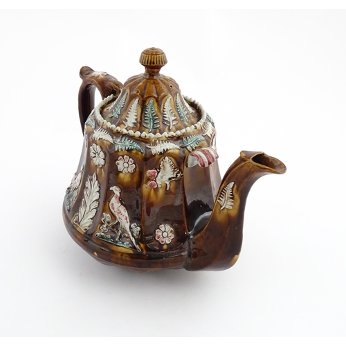 70 - A Victorian Measham bargeware teapot of fluted form decorated with flowers, ferns and birds. Approx.... 