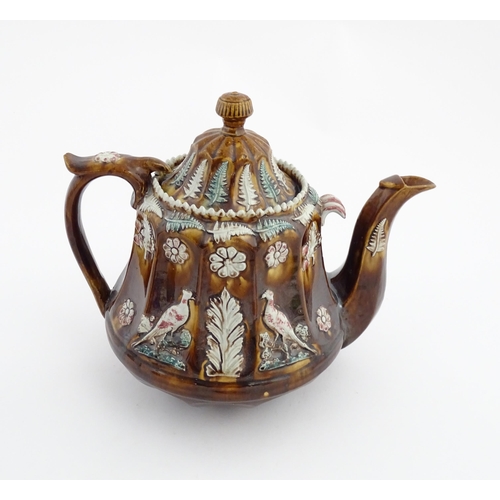 70 - A Victorian Measham bargeware teapot of fluted form decorated with flowers, ferns and birds. Approx.... 