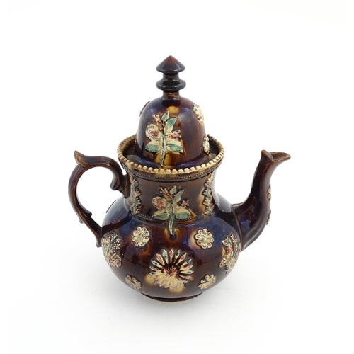 72 - A large Victorian Measham bargeware teapot decorated with flowers and foliage. Approx. 11 1/2