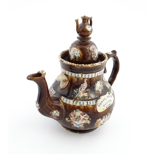 73 - A large George III Measham bargeware teapot, with teapot finial to lid, the body decorated with flow... 