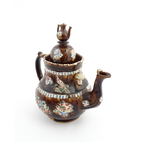 73 - A large George III Measham bargeware teapot, with teapot finial to lid, the body decorated with flow... 