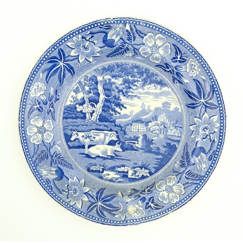 93 - A blue and white plate decorated in the Wiseton Hall pattern with cows resting in a landscape with a... 