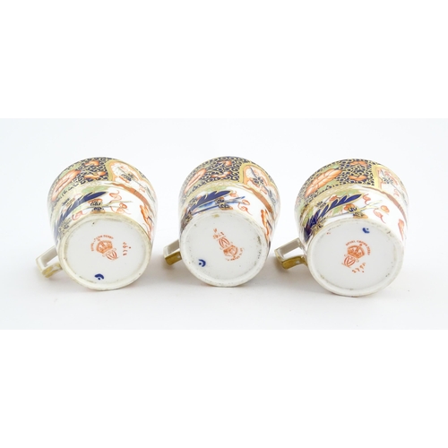 118 - Three Royal Crown Derby cups and saucers decorated in the Imari palette with floral and foliate deta... 