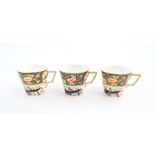 118 - Three Royal Crown Derby cups and saucers decorated in the Imari palette with floral and foliate deta... 