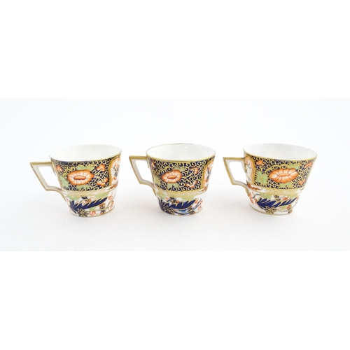 118 - Three Royal Crown Derby cups and saucers decorated in the Imari palette with floral and foliate deta... 