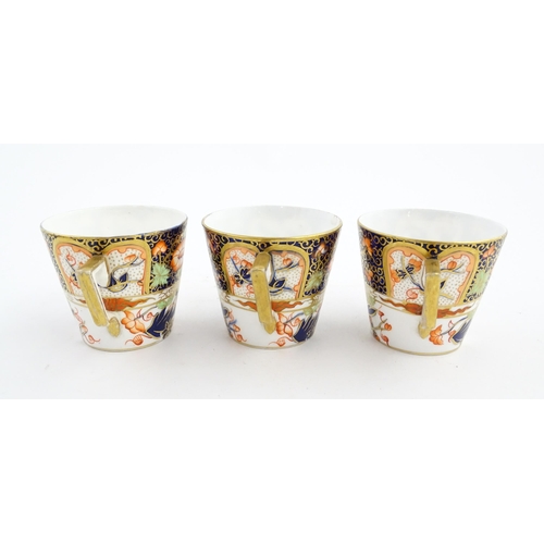 118 - Three Royal Crown Derby cups and saucers decorated in the Imari palette with floral and foliate deta... 