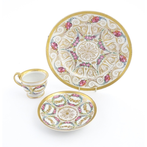 126 - A 19thC hand painted plate, cup and saucer decorated with floral swags and gilt scrolls. The plate i... 