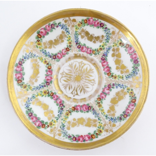 126 - A 19thC hand painted plate, cup and saucer decorated with floral swags and gilt scrolls. The plate i... 