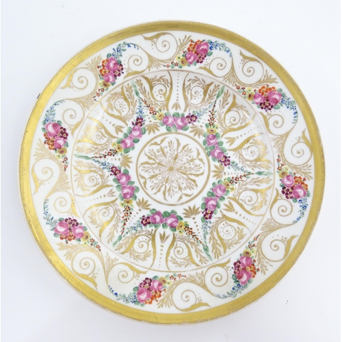 126 - A 19thC hand painted plate, cup and saucer decorated with floral swags and gilt scrolls. The plate i... 