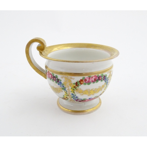 126 - A 19thC hand painted plate, cup and saucer decorated with floral swags and gilt scrolls. The plate i... 