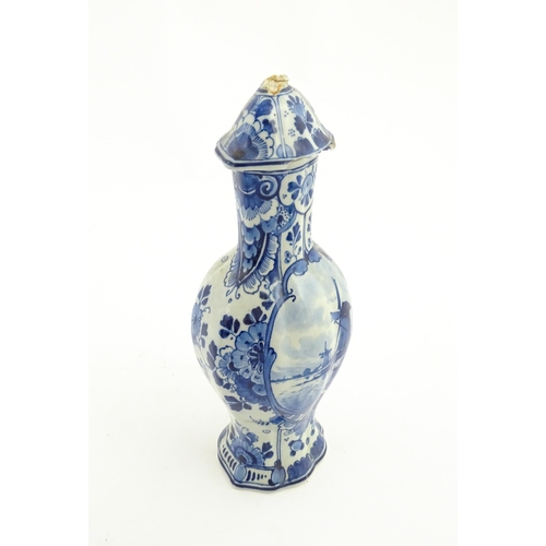 129 - A Dutch Royal Delft blue and white vase and cover decorated with flowers, foliage and a windmill sce... 