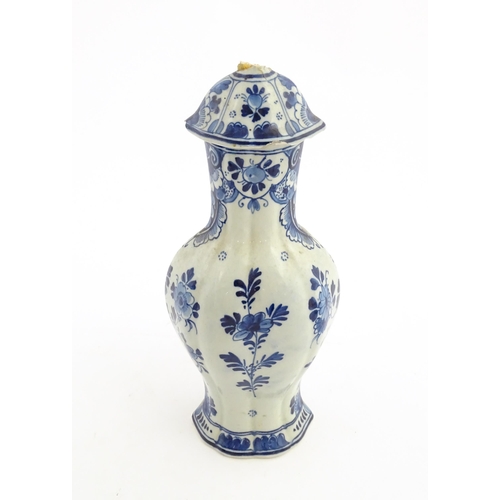 129 - A Dutch Royal Delft blue and white vase and cover decorated with flowers, foliage and a windmill sce... 