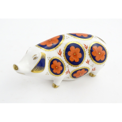 142 - A Royal Crown Derby paperweight modelled as a pig with flower detail. Marked under. Approx. 5 1/4