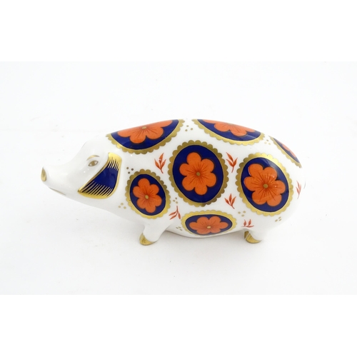 142 - A Royal Crown Derby paperweight modelled as a pig with flower detail. Marked under. Approx. 5 1/4