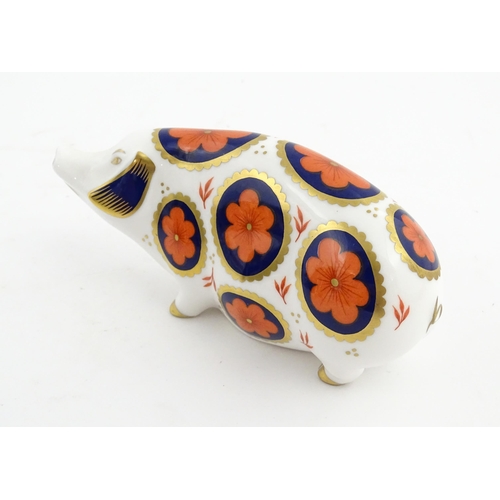 142 - A Royal Crown Derby paperweight modelled as a pig with flower detail. Marked under. Approx. 5 1/4