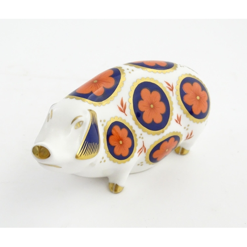 142 - A Royal Crown Derby paperweight modelled as a pig with flower detail. Marked under. Approx. 5 1/4