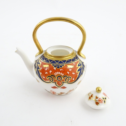 151 - A Royal Crown Derby plate and a miniature teapot decorated in the Imari palette. Marked under. Teapo... 