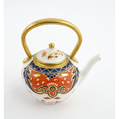 151 - A Royal Crown Derby plate and a miniature teapot decorated in the Imari palette. Marked under. Teapo... 