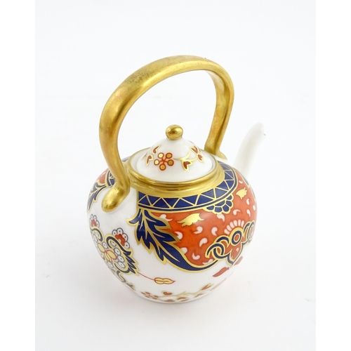 151 - A Royal Crown Derby plate and a miniature teapot decorated in the Imari palette. Marked under. Teapo... 