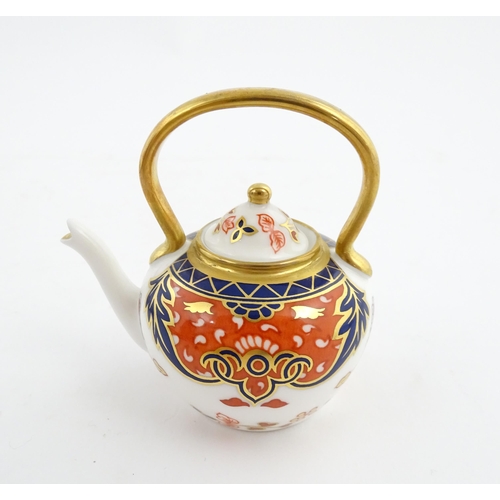 151 - A Royal Crown Derby plate and a miniature teapot decorated in the Imari palette. Marked under. Teapo... 