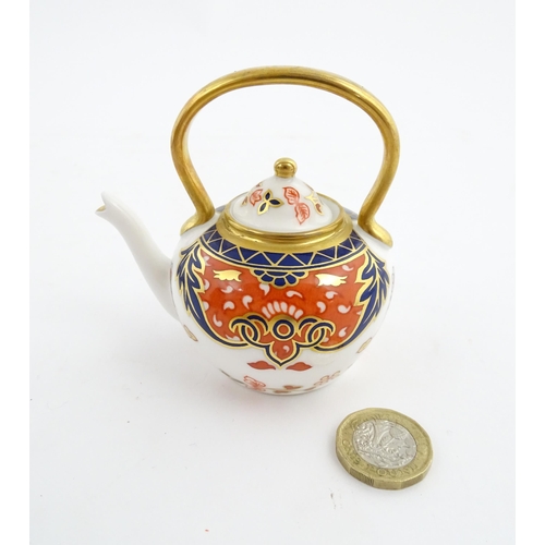 151 - A Royal Crown Derby plate and a miniature teapot decorated in the Imari palette. Marked under. Teapo... 