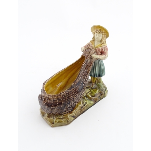 154 - A Victorian Torquay majolica pottery table salt modelled as a fisher girl with a net. Marked under W... 