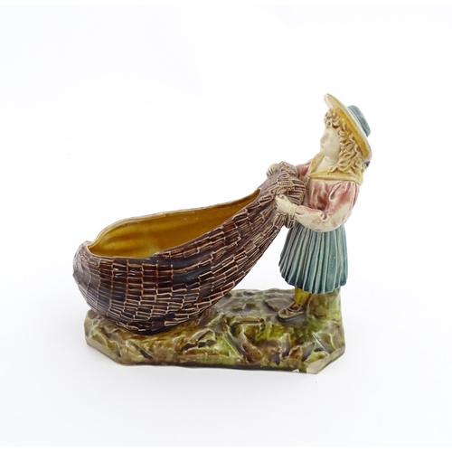 154 - A Victorian Torquay majolica pottery table salt modelled as a fisher girl with a net. Marked under W... 