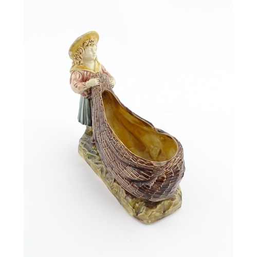 154 - A Victorian Torquay majolica pottery table salt modelled as a fisher girl with a net. Marked under W... 