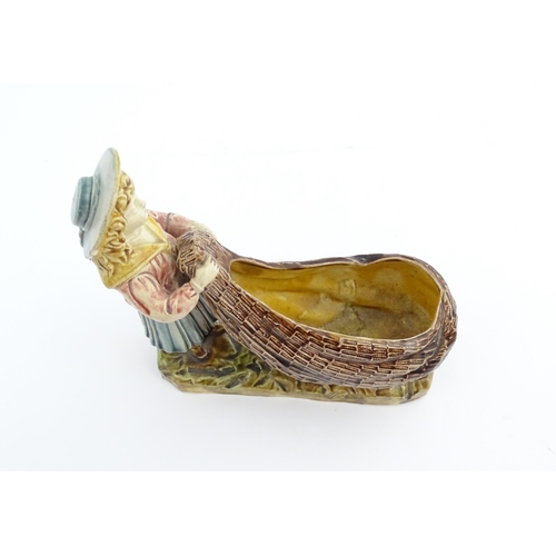 154 - A Victorian Torquay majolica pottery table salt modelled as a fisher girl with a net. Marked under W... 