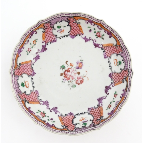 17 - A Chinese Export plate decorated with flowers and foliate with a scrolling border. Approx. 5 1/2