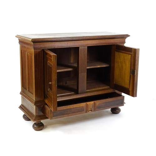 1559 - A late 19thC / early 20thC walnut cupboard with a moulded top above two panelled doors and a fluted ... 