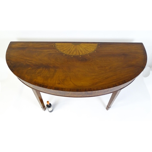 1636 - A large late 18thC mahogany serving table of demi lune form, having a marquetry inlaid top with sunb... 