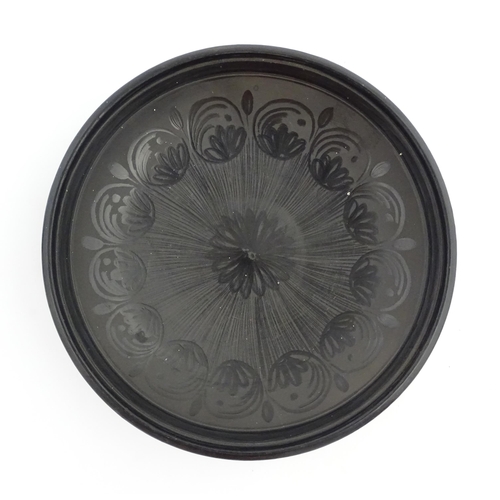 183 - A studio pottery dish with central flower detail and brushwork decoration. Incised under and signed ... 