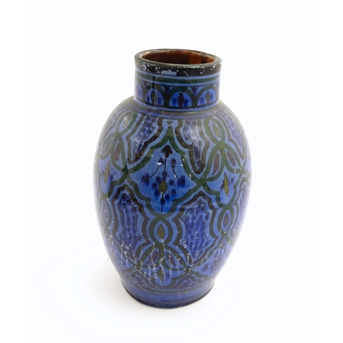 222 - A Moroccan terracotta vase the blue ground decorated with repeating motifs. Approx. 12 3/4