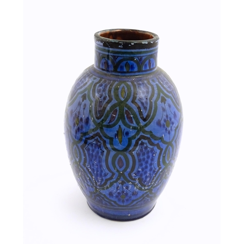 222 - A Moroccan terracotta vase the blue ground decorated with repeating motifs. Approx. 12 3/4