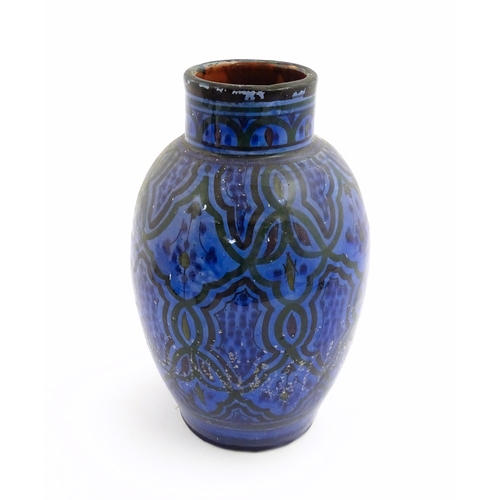 222 - A Moroccan terracotta vase the blue ground decorated with repeating motifs. Approx. 12 3/4