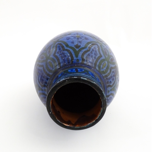 222 - A Moroccan terracotta vase the blue ground decorated with repeating motifs. Approx. 12 3/4