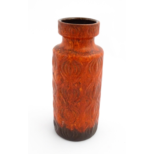 223 - A West German Scheurich vase with a red ground decorated in relief in the onion pattern. Approx. 12