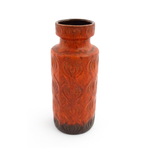 223 - A West German Scheurich vase with a red ground decorated in relief in the onion pattern. Approx. 12