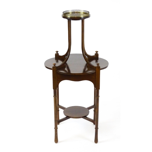 1440 - An Edwardian mahogany centre table, having a circular upper tier with a brass galley raised on four ... 