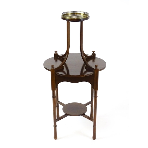 1440 - An Edwardian mahogany centre table, having a circular upper tier with a brass galley raised on four ... 