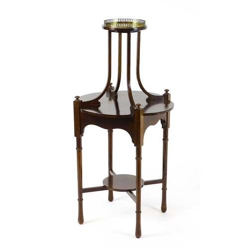 1440 - An Edwardian mahogany centre table, having a circular upper tier with a brass galley raised on four ... 