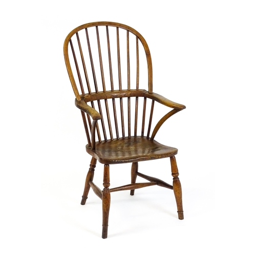 1441 - A 19thC double bow back Windsor chair with a shaped elm seat and raised on four turned tapering legs... 