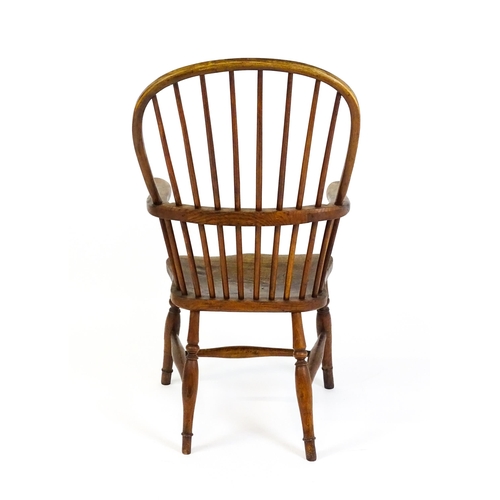 1441 - A 19thC double bow back Windsor chair with a shaped elm seat and raised on four turned tapering legs... 