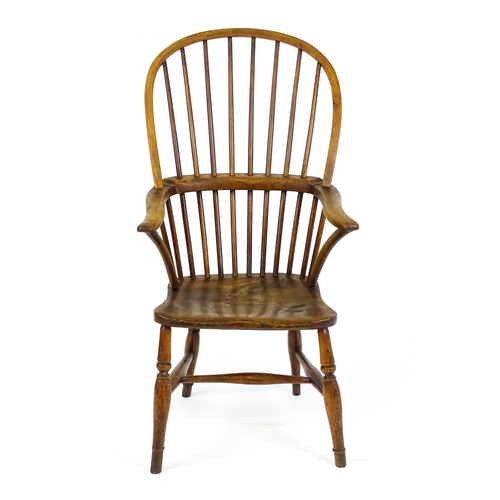 1441 - A 19thC double bow back Windsor chair with a shaped elm seat and raised on four turned tapering legs... 