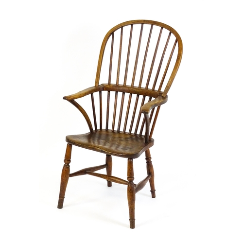 1441 - A 19thC double bow back Windsor chair with a shaped elm seat and raised on four turned tapering legs... 