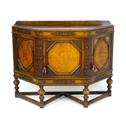 1561 - A late 19thC / early 20thC oak and walnut cabinet with an oak upstand, above blind fretwork carving ... 